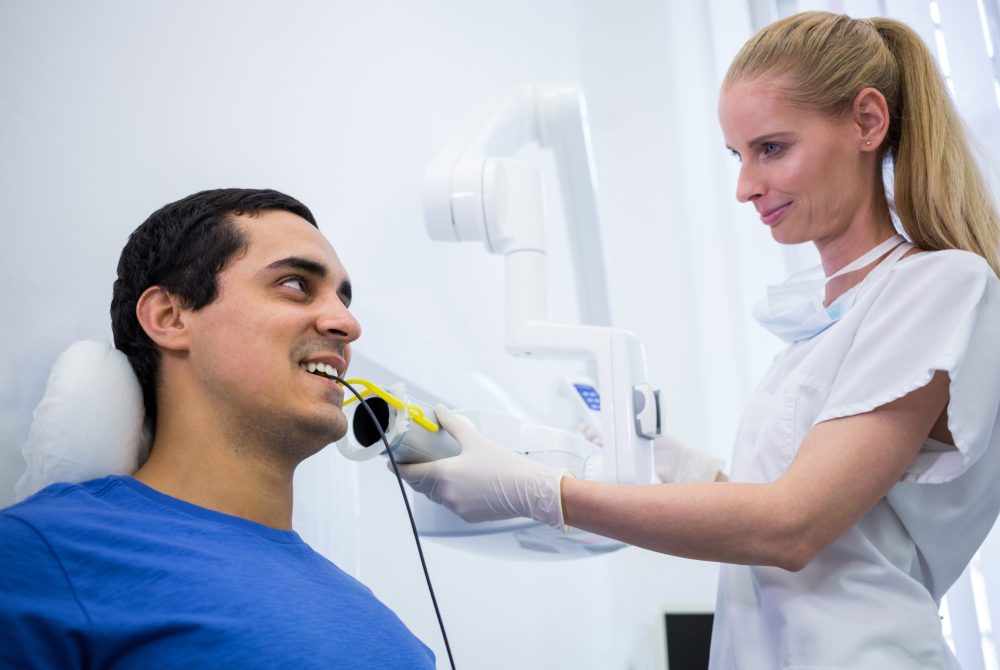 Dentist taking a male patients tooth x-ray in clinic